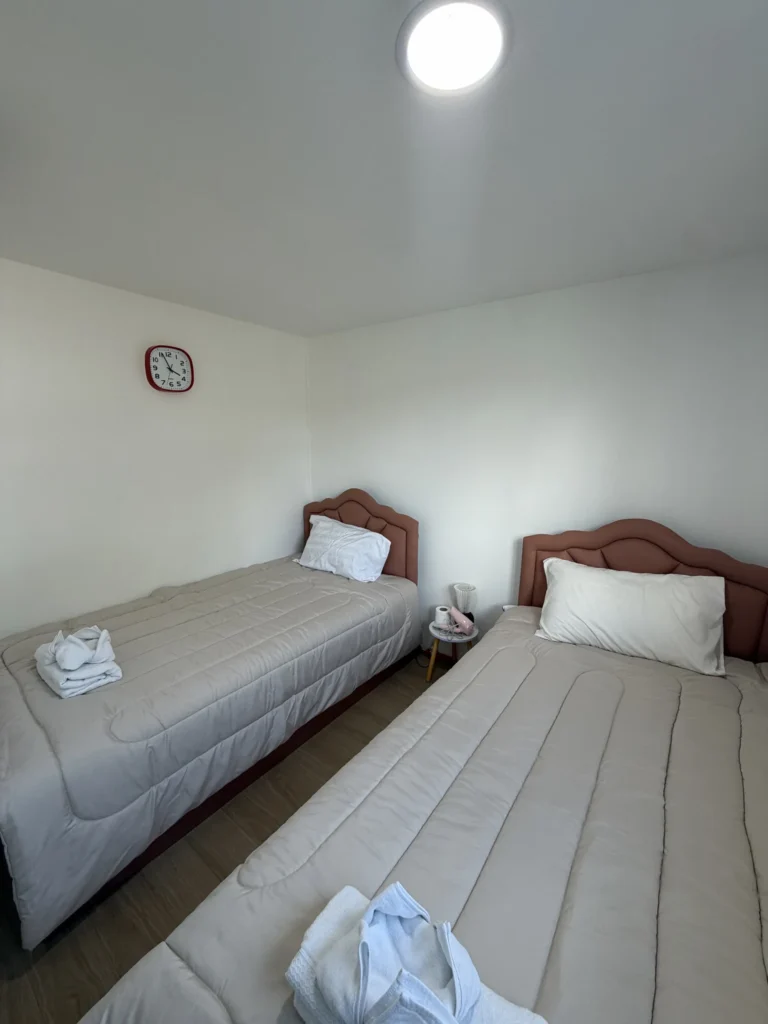 Two single beds with towels in a room at Don Mueang Park and Fly